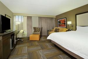 a hotel room with a bed and a flat screen tv at Hampton Inn Philadelphia-Great Valley in Frazer