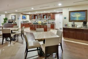 una gran cocina con mesas, sillas y una encimera. en Homewood Suites by Hilton San Diego-Del Mar, en San Diego