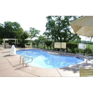 een groot zwembad met een parasol en stoelen bij Hampton Inn & Suites Red Bluff in Red Bluff