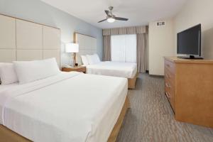 a hotel room with two beds and a flat screen tv at Homewood Suites by Hilton San Diego-Del Mar in San Diego