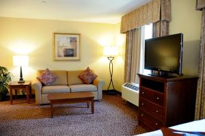 a hotel room with a couch and a flat screen tv at Hampton Inn & Suites Red Bluff in Red Bluff