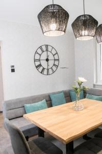 a dining room with a table and a clock on the wall at Triumph Inn Ferienhaus in Rangsdorf