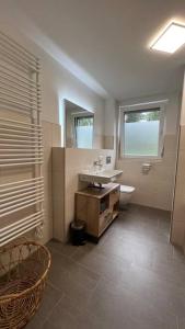 baño con lavabo y aseo y ventana en Modernes Apartment, en Rangsdorf