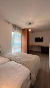 a bedroom with a bed and a flat screen tv at Modernes Apartment in Rangsdorf