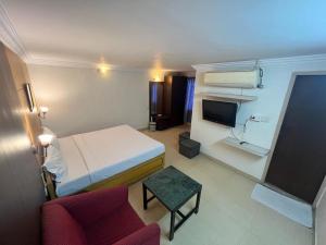 a hotel room with a bed and a couch and a tv at Hotel City Tower, Chennai Central in Chennai