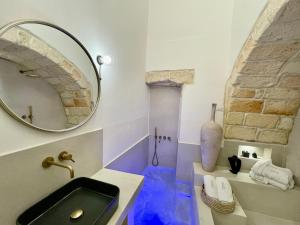 uma casa de banho com um lavatório preto e um espelho em I Granai - Marea Collection em Nardò