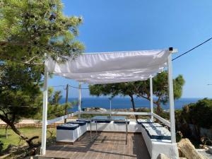 un cenador blanco con vistas al océano en Kallithea Residence en Koskinou