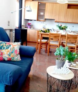 sala de estar con sofá azul y cocina en La Rocconella, en Arten