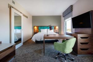 um quarto de hotel com uma secretária e uma cama em Hampton Inn & Suites Edmonton St. Albert, Ab em Edmonton