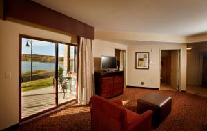 a living room with a television and a balcony at Hampton Inn Marquette-Waterfront in Marquette