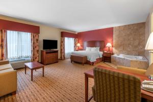 um grande quarto de hotel com uma cama e uma televisão em Hampton Inn & Suites Arcata em Arcata
