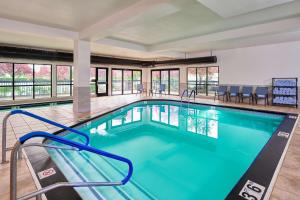a pool with blue water in a building with windows at Hampton Inn Anchorage in Anchorage