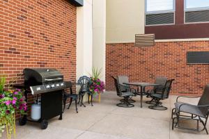 un patio con parrilla, mesas y sillas en Hampton Inn Wausau en Wausau