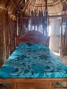 a bedroom with a bed with a blue comforter at D-Gunayar Experience in Cabins classic in Arritupo Número Dos