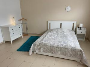 1 dormitorio con 1 cama, vestidor y reloj en Großzügige Wohnung mit Schreibtischarbeitsplatz in Genthin OT Tucheim, en Tucheim