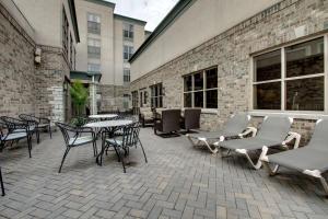 eine Terrasse mit Tischen und Stühlen vor einem Gebäude in der Unterkunft Hampton Inn & Suites Chicago/Aurora in Aurora