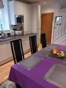 a kitchen with a table with a bowl of fruit on it at BODLONDEB CASTLE BED & BREAKFAST { CENTRAL LLANDUDNO} in Llandudno