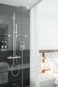 a bathroom with a shower and a bed at Ruby Stella Hotel London in London
