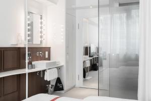 a bathroom with a shower and a sink and a mirror at Ruby Stella Hotel London in London