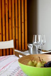 un bol de fruta en una mesa con copas de vino en Casa da Eira, en Marco de Canaveses