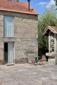 two red chairs sitting outside of a stone building at Casa da Eira in Marco de Canaveses