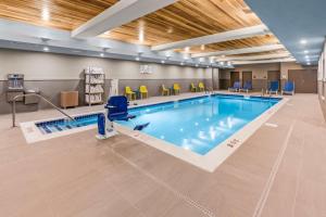 una piscina en una habitación de hospital con sillas amarillas en Home2 Suites By Hilton North Conway, NH, en North Conway
