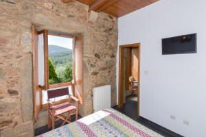 a bedroom with a bed and a window with a view at Casa do Pinto in Arouca