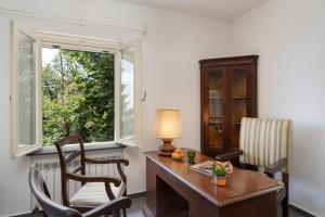 um escritório com uma secretária e cadeiras e uma janela em Casa Sul Serra em Calci