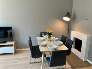 a dining room with a table with chairs and a tv at Majorstua, charming and modern 2 bedroom apartment in Oslo
