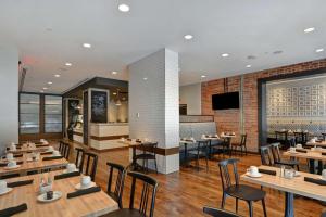 a dining room with wooden tables and chairs at The Cincinnatian Curio Collection by Hilton in Cincinnati