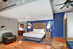 a bedroom with a king sized bed and a chair at The Cincinnatian Curio Collection by Hilton in Cincinnati