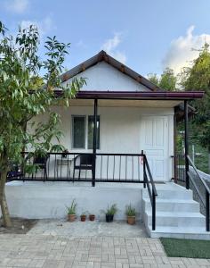 a small white house with a porch and stairs at BANI tsikhisdziri in Ts'ikhisdziri