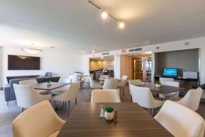 a restaurant with tables and chairs and a television at DoubleTree by Hilton Dallas/Richardson in Richardson