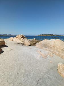 una spiaggia con rocce e l'oceano sullo sfondo di Appartamento Veronese a Olbia