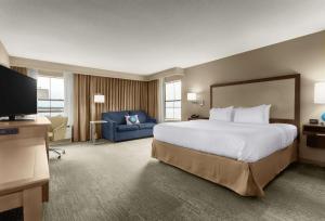 a hotel room with a large bed and a blue couch at Hampton Inn Georgetown-Marina in Georgetown