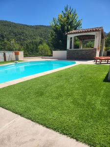 a swimming pool with a gazebo and green grass at Chambre d'hôtes Lobéal in Auriol