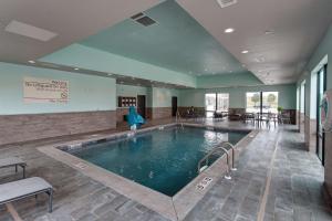 una grande piscina in una grande stanza con sedie e tavoli di Hampton Inn & Suites-Wichita/Airport, KS a Wichita