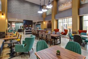 Hampton Inn & Suites-Wichita/Airport, KS في ويتشيتا: غرفة طعام مع طاولات وكراسي