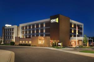 Menomonee FallsHome2 Suites By Hilton Menomonee Falls Milwaukee的一座大型酒店建筑,上面有hmc标志