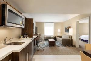 um quarto de hotel com uma cozinha e uma sala de estar em Home2 Suites By Hilton Menomonee Falls Milwaukee em Menomonee Falls
