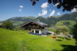 una casa su una collina con le montagne sullo sfondo di Molto Haus a Raggal