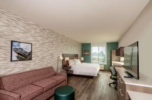 une chambre d'hôtel avec un lit et un canapé dans l'établissement Home2 Suites By Hilton Riverside March Air Force Base, Ca, à Riverside