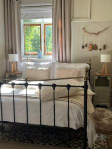 a bedroom with a bed with white sheets and a window at The Snug at Littledown in Lewes