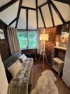 a living room with a couch and a brick wall at The Snug at Littledown in Lewes