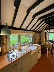 a kitchen with a stove top oven next to a table at The Snug at Littledown in Lewes