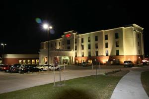 un grand bâtiment blanc avec un parking la nuit dans l'établissement Hampton Inn Topeka, à Topeka