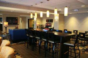 a restaurant with a bar with chairs and a table at Hampton Inn Topeka in Topeka