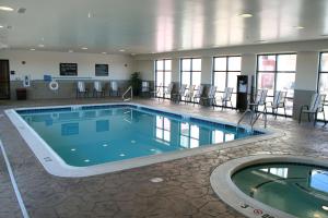 a large swimming pool in a building with tables and chairs at Hampton Inn Topeka in Topeka