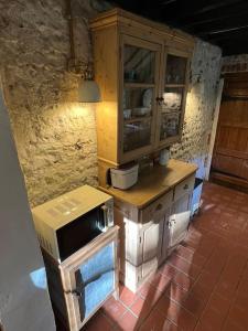 a kitchen with a wooden cabinet and a stove at The Snug at Littledown in Lewes