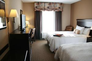 a hotel room with two beds and a television at Hampton Inn Topeka in Topeka